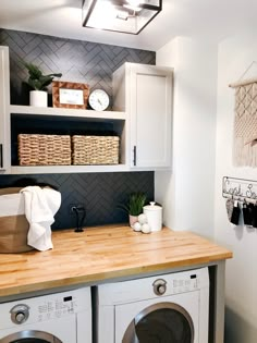 a washer and dryer sitting in a room next to each other on top of a wooden counter