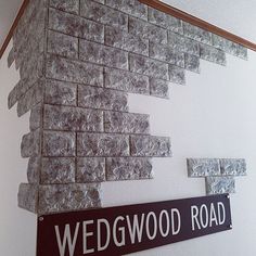 there is a sign that says wedgwood road next to a wall made out of bricks