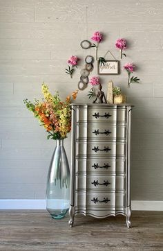 a silver dresser with flowers in a vase on top