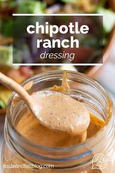 a jar filled with peanut butter sitting on top of a table next to a wooden spoon