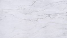 a white marble textured surface with grey streaks