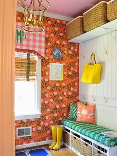 a room with colorful wallpaper and baskets on the shelves, along with yellow rain boots