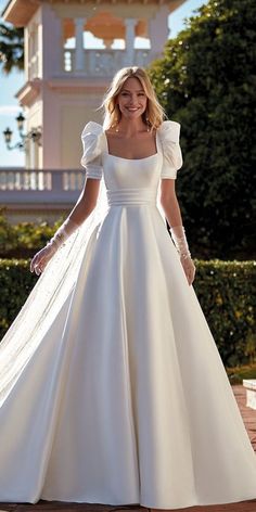 a woman in a white wedding dress posing for the camera