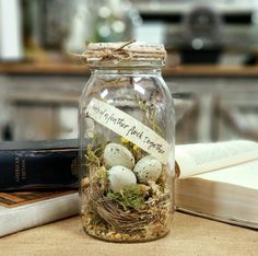 a jar filled with eggs sitting on top of a table next to an open book