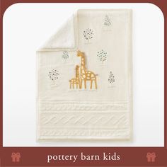 a white towel with gold giraffes on it and the words pottery barn kids