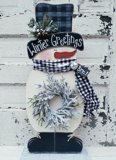 a snowman made out of a toilet with a christmas wreath on the top and an antlers'greetings sign above it