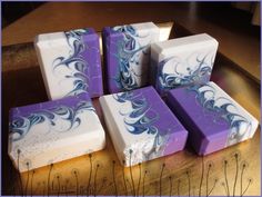 six soap bars with blue and white designs on them sitting on a wooden table top