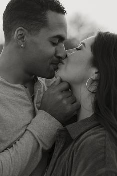 a man and woman kissing each other in black and white