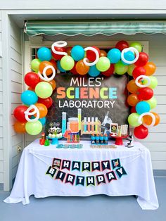 a science lab birthday party with balloons and streamers in the shape of an arch