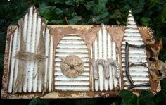 an old clock sitting on top of a piece of wood next to some ivys