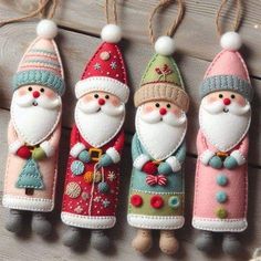 four christmas ornaments hanging from strings on a wooden surface with string attached to the handles