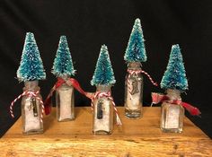 four mason jars with christmas trees in them