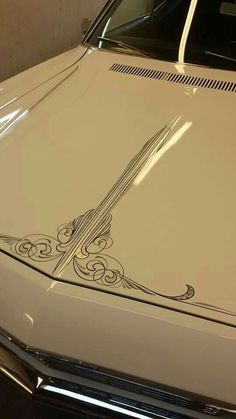 a white car with a decorative design on the hood