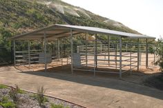 a metal shelter on the side of a dirt road