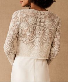 the back of a woman's wedding dress with lace on top and sleeves,