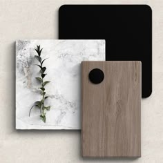 two square coasters, one with a plant on it and the other with a black dot