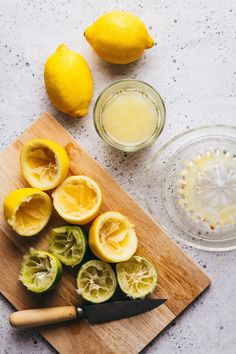 sliced lemons on a cutting board next to a knife and bowl with liquid in it