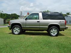 a silver truck parked on top of a lush green field