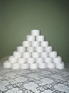 a pile of toilet paper sitting on top of a table next to a green wall