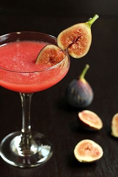 a glass filled with a red liquid and sliced figs