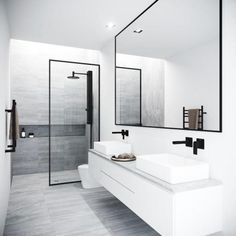 a white bathroom with two sinks and mirrors