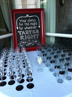 there are many wine glasses on the table with a chalkboard sign behind them that says your place for the night for whatever tastes right