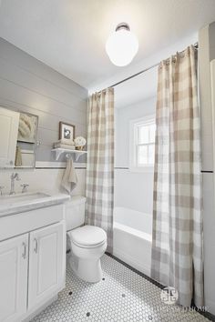 a bathroom with a toilet, sink and shower curtain