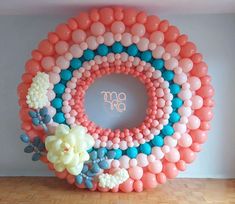 a large balloon wreath with flowers on it