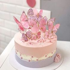 a pink and purple cake with butterflies on top