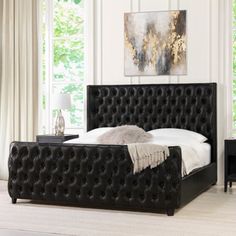 a black bed with white sheets and pillows