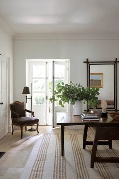 a living room filled with furniture and a large mirror on the wall next to a door