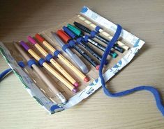 a bunch of crayons are sitting in a box on the table next to a blue cord