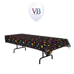 a table with a balloon floating above it and a black tablecloth that has smiley faces on it