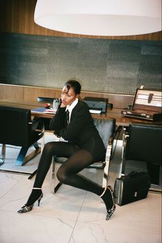 a woman sitting in a chair with her legs crossed