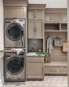 a washer and dryer in a small room with cabinets on either side of it