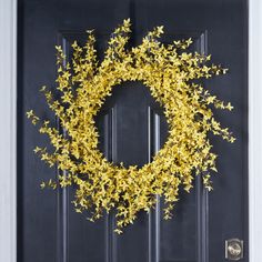 a black door with a yellow wreath on it