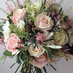 a bouquet of flowers sitting on top of a white table next to a person's hand