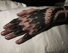 a person's hand with black and white tattoos on it