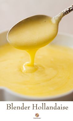 a spoon full of yellow liquid being poured into a white bowl with the lid open