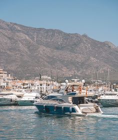 several boats in the water with mountains in the background