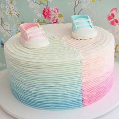 a multicolored cake with baby shoes on top