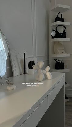 there is a white desk with many items on it and a mirror in the corner