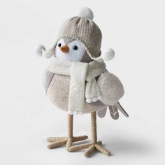 a stuffed penguin wearing a knitted hat and scarf