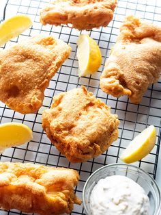 fried fish on a cooling rack with lemons and mayonnaise