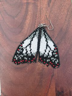 a pair of black and white beaded butterfly earrings