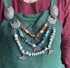 a woman wearing an apron with beads and charms on it