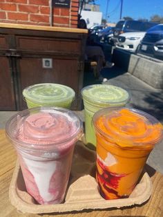 three different types of ice cream sitting on top of a wooden tray next to each other