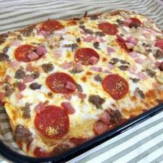 a square pizza with pepperoni, sausage and cheese in a pan on a table