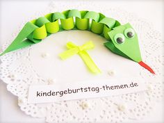 a paper plate with a green caterpillar and a yellow cross on it that says kindergebursttag thermen de