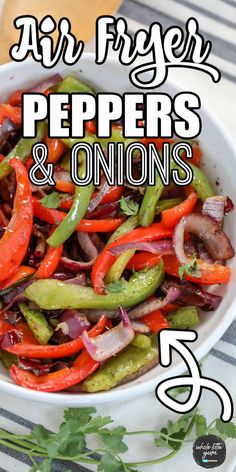 a white bowl filled with peppers and onions on top of a striped table cloth next to a glass of beer